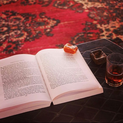 book open on a small table with a crystal laying on the pages