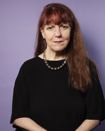 Caridad Svich looking at camera