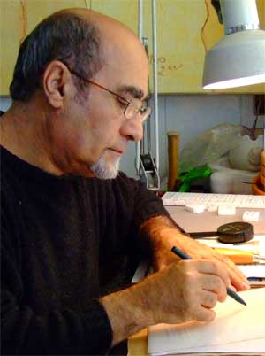 Photo of man in black t-shirt drawing at a desk