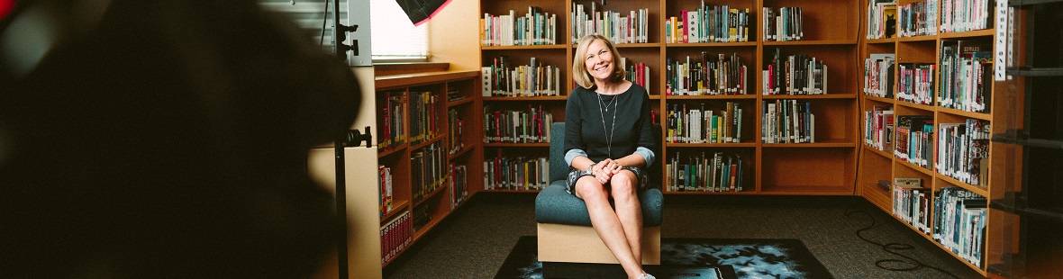 Woman being filmed in a room with books behind her CREDIT Sam McGhee on Unsplash