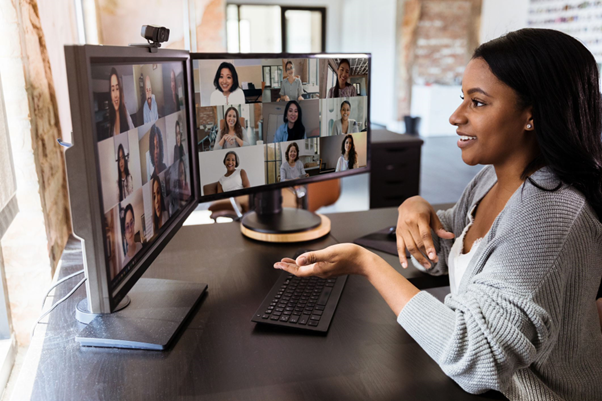 Female in online Teams meeting with 2 computer monitors