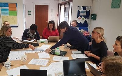 Image shows a group of learners from Willen Hospice in Milton Keynes engaging in an interactive activity around a table