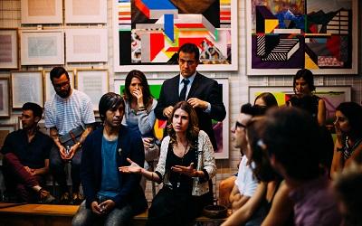 Image shows a group of individuals in a meeting with a female in the centre who is speaking. She looks like she is asking a question. Photo credit Antenna on Unsplash