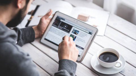 Man using iPad with a cup of coffee