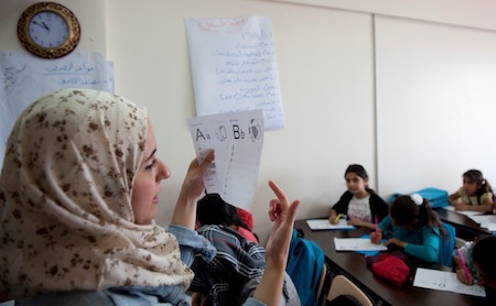 photo of teacher teaching refugee children