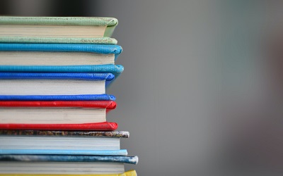 A colourful pile of books rest upon each other