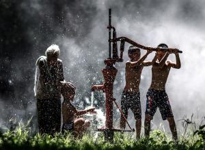 photo of boys and grandmother at a water pump in Thailand