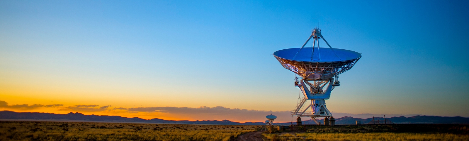 A picture of a satellite in front of a sunset