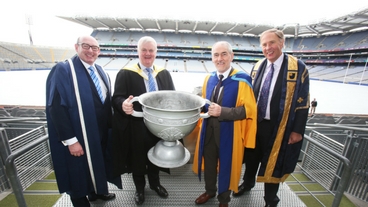 a group of people pose for a photo holding a massive trophy