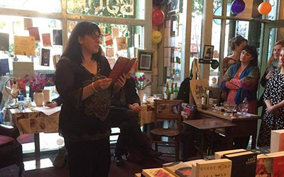 Woman reading a book in a small local shop.