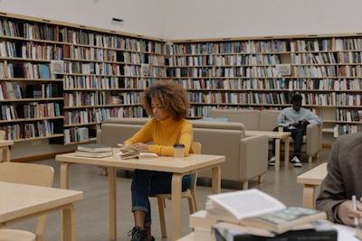 A female student sitting in a library, studying
