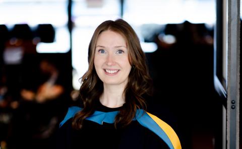 Fiona smiles wearing her graduation robe