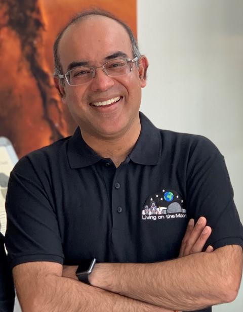 A man with the 'Living on the Moon' logo on his t-shirt smiling to camera