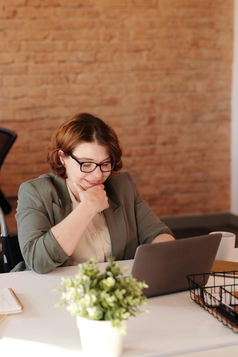 A person sitting at a table with a computer. Photo by Marcus Aurelius.