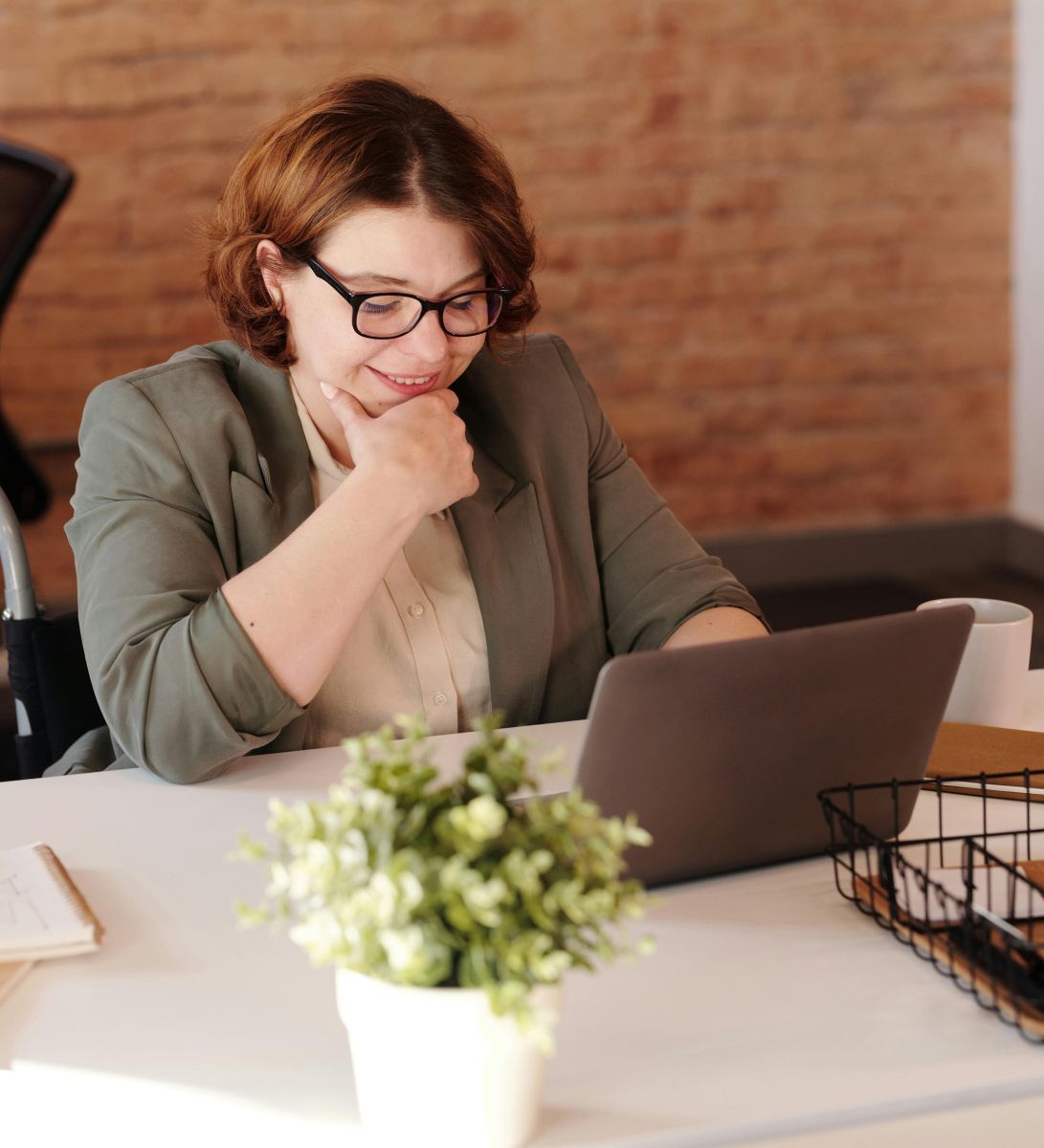 A person sitting at a table with a computer. Photo by Marcus Aurelius.