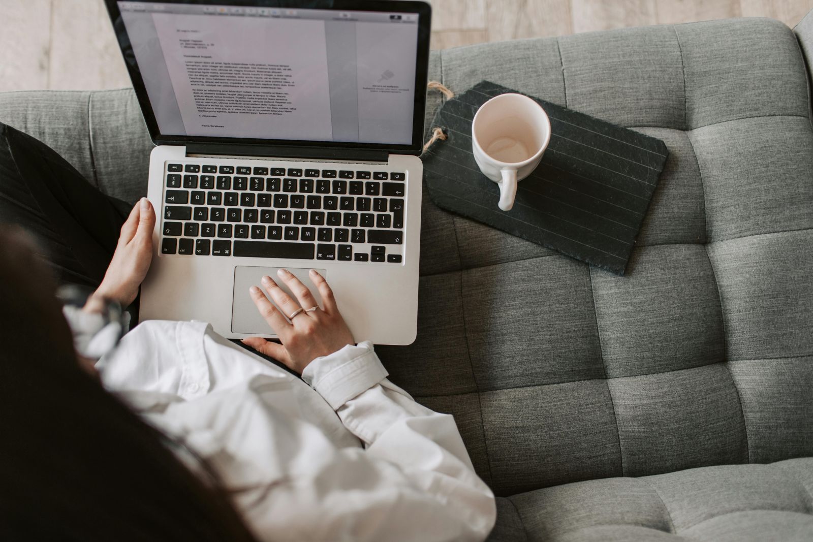 A person using a computer on a couch. Photo by Vlada Karpovich.