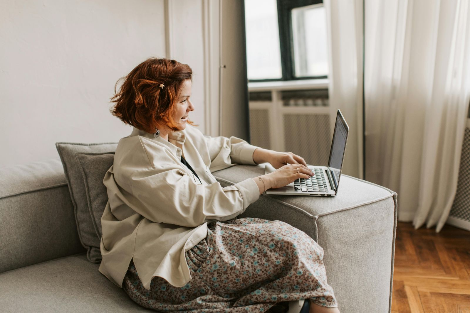 A person sitting on a couch using a computer. Photo by Vlada Karpovich.