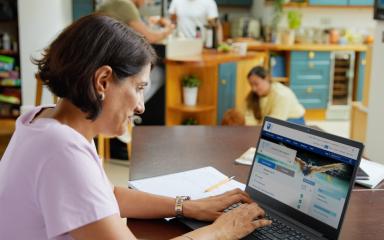 Student working from home with her family around her