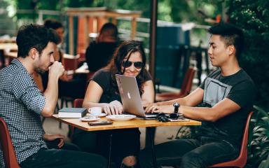 three students studying outside