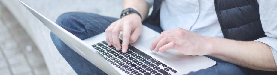 Student outside working on a laptop