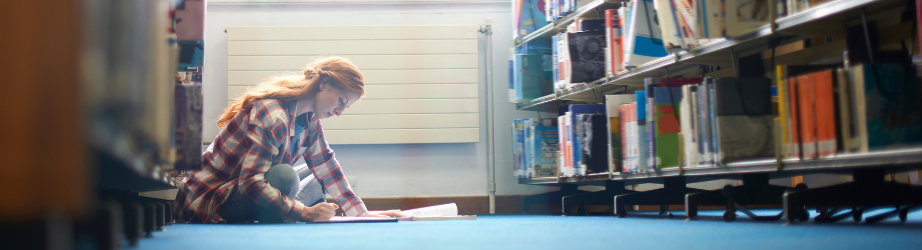 Student working on the floor in the library