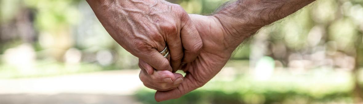 Two people holding hands walking outside