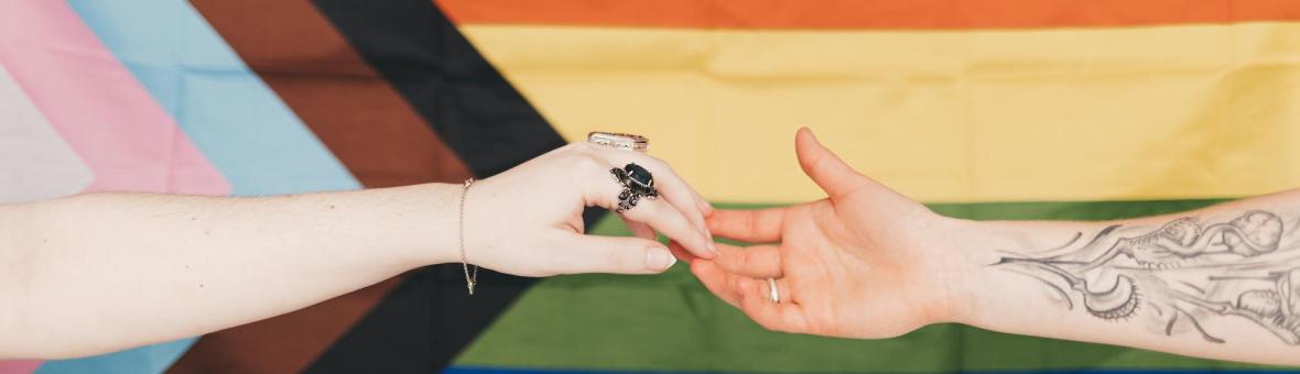 hands reaching across LGBTQ+ flat