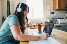 Student wearing headphones, working on a laptop