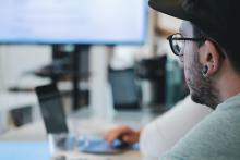 Side profile of male in a computer environment looking at a large video screen