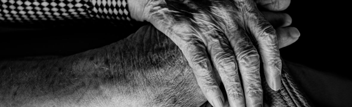 A picture of an elderly person's hand holds another hand