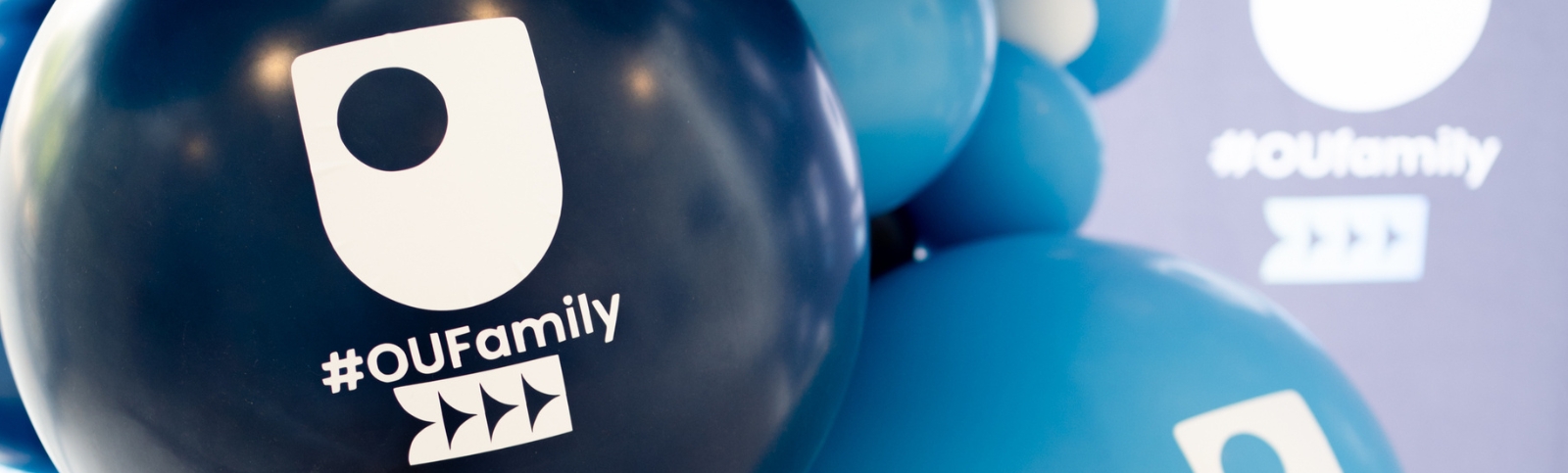 A series of blue balloons with The Open University logo on them