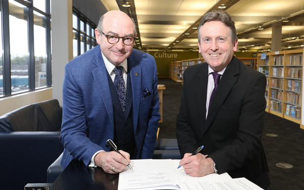 two men signing a document