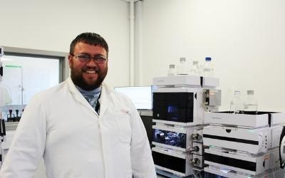 Peter standing in a lab coat in a lab