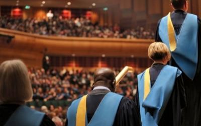 graduates in robes lined up ready to go on stage