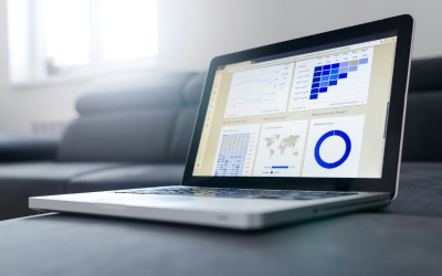 A laptops sits on a table with graphs on the screen