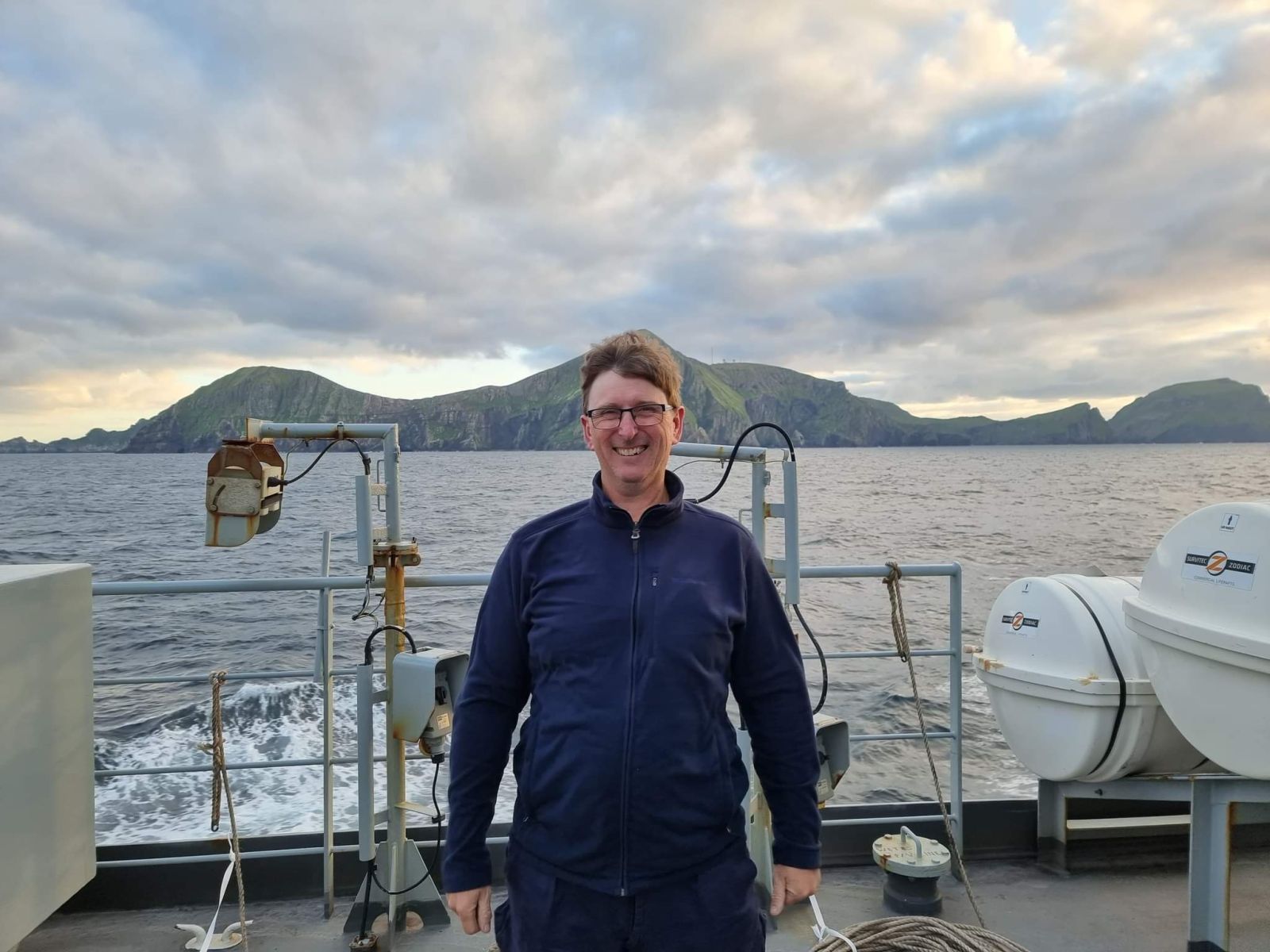 William standing on the deck of a ship out at sea