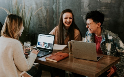 a group of students study at a table together and are laughing