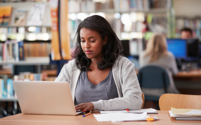 image of a woman studying at a desk with her computer