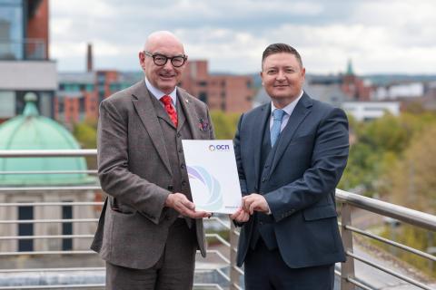 John D'Arcy and Martin Flynn standing holding a document together