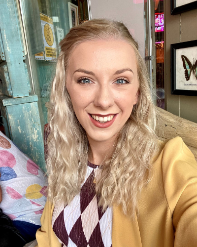 a blonde woman smiles into the camera