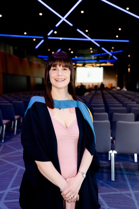 Lynsey stood smiling to camera in the graduation hall at Croke Park.