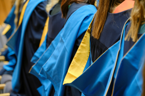 A photo showing the back of Open University students wearing their degree ceremony robes.