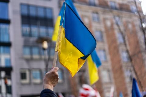 a Ukrainian flag is held up by an arm