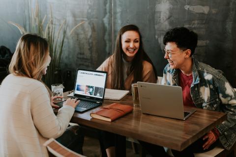 a group of people studying at a table and laughing