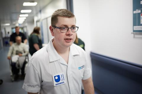  a male nurse in an Open University student nurse tunic