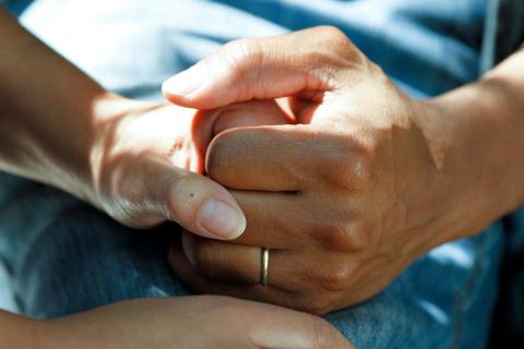 A pair of hands embracing on someone's lap