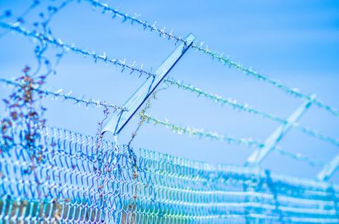 Barbed wire above a fence.