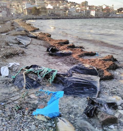 Abandoned plastic dinghies on a beach.