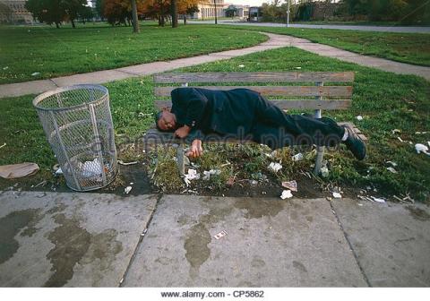 A man sleeping on a park bench.