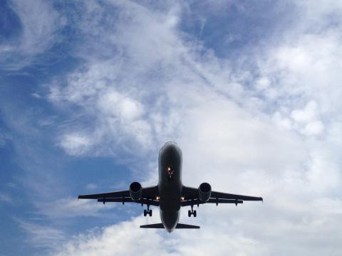 Ground level view of the underside of a plane.